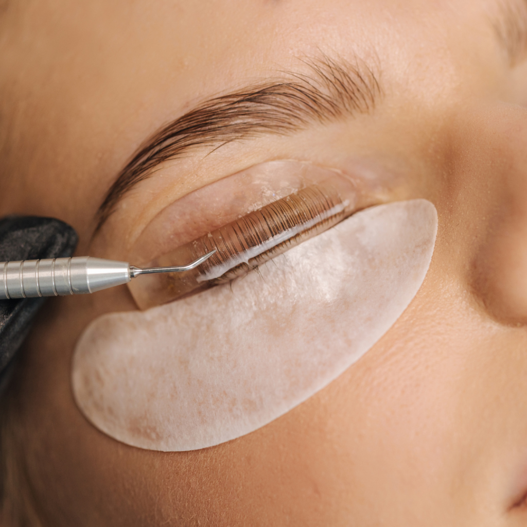 Nahaufnahme während eines Lash Liftings – eine Kundin erhält die Behandlung mit Silikonpads und Pflegeprodukten für dauerhaft geschwungene Naturwimpern.